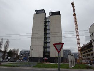 alter Wohnblock mit Neubau im Hintergrund 2015